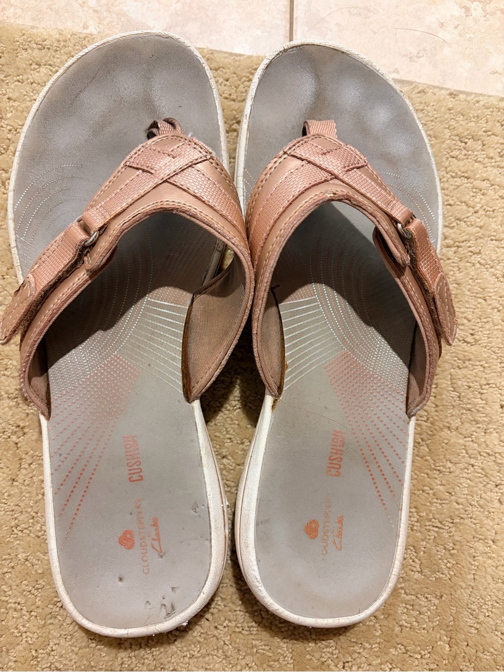 Well worn Clarks Women’s Rose Gold flip flops